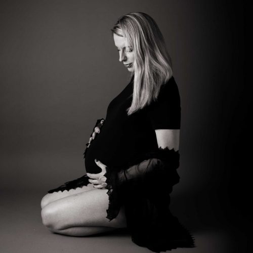 Picture of pregnant mother cradling her precious bump. The image is in black and white.